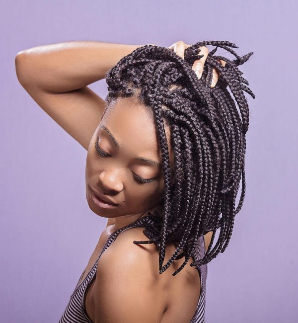 pexels-photo-713527-713527 Elegant portrait of a woman showcasing braided hairstyle against a purple background.